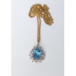 A 9ct gold chain with unmarked white metal pendant set with cubic zirconia and central blue paste