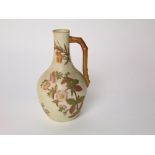 A Royal Worcester ivory ground jug with painted and gilded floral decoration and simulated gilded