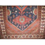 A Persian wool floor rug centrally decorated with large medallions and diaper panels upon a rich