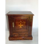 An Edwardian walnut and box wood inlay smokers cabinet the hinged door inlaid with a twin handled