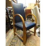 An early 20th century Art Deco oak carver chair of stylised form with curved arms and blue leather