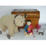 A tin trunk containing a collection of various vintage toys to include a polar bear on a trolley and