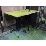 A pair of contemporary bistro tables with square beech tops raised on cast iron bases