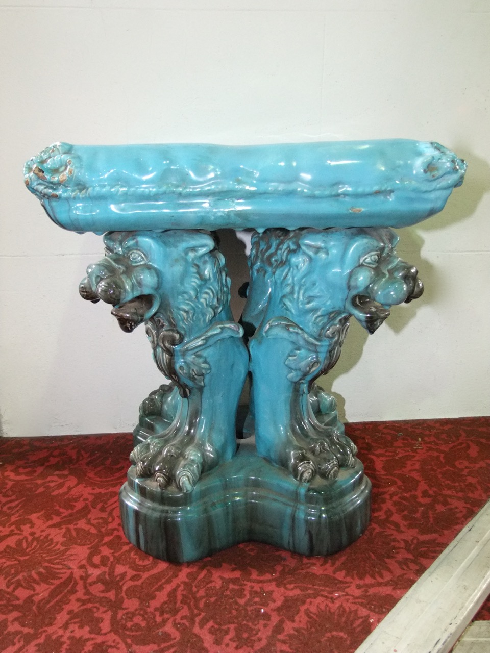 A 19th century turquoise glazed majolica stool in the form of a simulated cushion with tassel detail