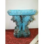 A 19th century turquoise glazed majolica stool in the form of a simulated cushion with tassel detail