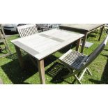 A Barlow Tyrie teak wood garden table with slatted top and two matching folding chairs