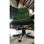 A Stressless arm chair and stool in a mid green leather colourway