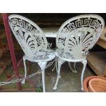 An aluminium terrace table of circular form together with two matching chairs with floral detail and