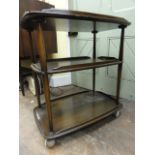 An Ercol dark elm three tier tea trolley, 79 cm high x 72 cm long approx