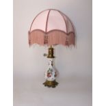 A late 19th century continental ceramic lamp base with painted floral sprays and with cast brass