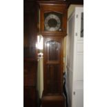 A 1920 period oak longcase clock, the front elevation enclosed by three bevelled edged glass plates,