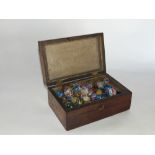 A 19th century rosewood box containing 85 Victorian glass marbles, mostly with latticino work