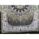 A contemporary Persian silk carpet decorated with various floral medallions upon a lime green