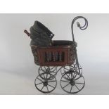 19th century cane work miniature dolls pram, on a wrought iron from and wheels