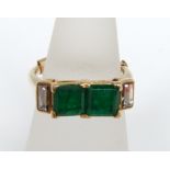 An emerald and diamond ring mounted by Cartier in unmarked yellow metal with two central square