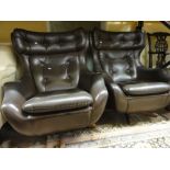 A pair of 1960s Parker Knoll egg type swivel chairs with brown leather upholstery (2)