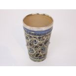 A Doulton Lambeth beaker with relief moulded scrolling and flower head detail with silver mount,