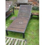 A contemporary garden lounger with stove enamelled framework and teak wood laths together with a