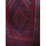 A Meshwari runner decorated with red diamond shaped medallions upon a blue ground, 64cm x 233cm