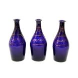 A set of three early 19th century Bristol blue type glass bottles, all with gilded simulated