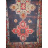 A Persian type floor rug centrally decorated with various red medallions upon a navy blue ground,
