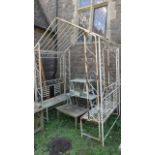 A gazebo with decorative scroll worked finish enclosing two simple benches