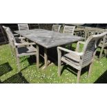 A teak wood extending dinning table with slatted top together with six matching garden chairs