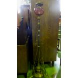 A brass freestanding oil lamp in the manner of Benson with cranberry glass bowl, 130 cm high approx