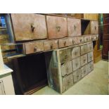 A 19th century pine run of twelve drawers (4 x 3) with original stained finish and brass buttoned