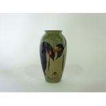 A Moorcroft vase with moulded and painted penguin and chick decoration on a pale grey/green ground