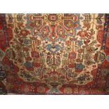 A Persian type floor rug decorated with various red and blue flowers upon an ivory ground, 232cm x