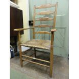 A Cotswold school ash wood ladder back armchair of traditional form with rush seat