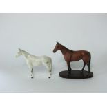 A Beswick model of a standing horse with dappled grey patches on a white ground together with a