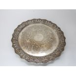 Good large Victorian silver circular tray raised on three bun feet with engraved and chased