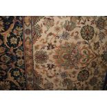 A large Persian style wool carpet with soft pink field and abstract floral, animal and other