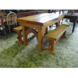 A rustic oak refractory table, the heavy planked top raised on four chamfered supports united by