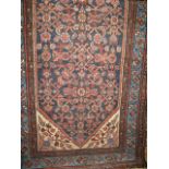 A Persian floor rug with central floral blue panel amidst brown floral banded borders, 210cm x
