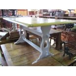 An Oak refectory table, the stripped rectangular top raised on painted supports with pegged rails