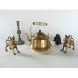 A pair of eastern brass drips in the form of lions, together with a galvanised metal candlestick,