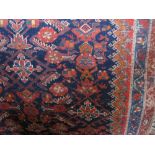 A Persian type floor runner decorated with elaborate floral medallions upon a navy blue ground,
