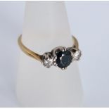 An 18ct gold sapphire and diamond three stone ring, central oval cut sapphire 7mm x 6mm, accented