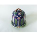 A large Majolica cheese dish and cover of dome shaped form with relief moulded and painted