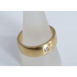 An 18ct gold wedding band set with single small square cut diamond 17.4g. Ring size W