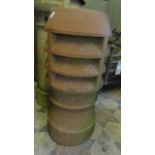 A tall reclaimed chimney pot of cylindrical form with louvre vented top together with two similar