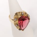 A 1970s ladies dress ring in unmarked yellow metal with large free cut central rubelite (red)