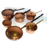 A collection of matched graduated copper pans with lids together with a further copper warming