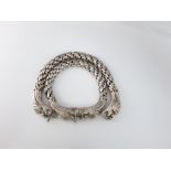 A pair of Chinese white metal articulated bracelets terminating in stylised dragons head clasps,