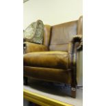 A contemporary wing chair in a Georgian style with light tan coloured finish with brass stud work