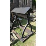 A reclaimed cast iron well head with A framed canopy raised on a pair of shaped supports with