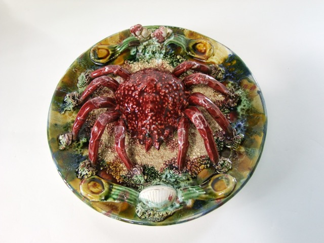 A continental dish with relief moulded and painted decoration incorporating a large crab, shells,